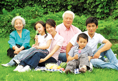 Beijing, Beijing, China --- Family Sitting on Lawn --- Image by © Astock/Corbis