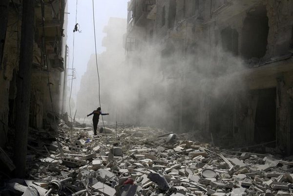 Một người dân bước qua đống đổ nát sau cuộc không kích tại khu vực do nhóm phiến quân chiếm đóng ở gần thành phố Aleppo, Syria ngày 25/9